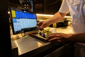 Chef plating a fine dining dish in a professional kitchen