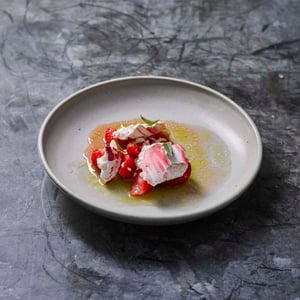 Verfijnd gerecht met vis en kleurrijke garnituren op een keramisch bord