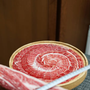 Vers gesneden Iberische ham, klaargemaakt voor een verfijnde dinerervaring.