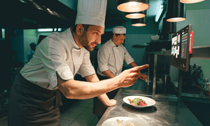 Chef using an Annoncer Prestige kitchen display during fine dining service