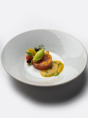Een elegant visgerecht van hoge kwaliteit met seizoensgroenten en een levendige saus bij Restaurant Bridges in Amsterdam.