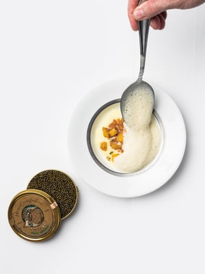 Een chef-kok legt de laatste hand aan een gerecht voor een chique diner met een luchtige espuma in Restaurant Bridges in Amsterdam.