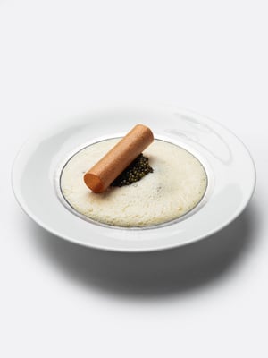 Een verfijnd kaviaargerecht met luchtige espuma en knapperige garnering, geserveerd in Restaurant Bridges in Amsterdam.