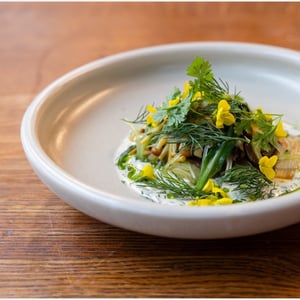 Een seizoensgerecht met groenten, geserveerd bij Restaurant De Kas in Amsterdam, bereid met ingrediënten die ter plaatse worden geteeld.