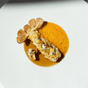Een verfijnd dessert met ijs, knapperige elementen en sinaasappelsorbet bij Create by Guido Braeken