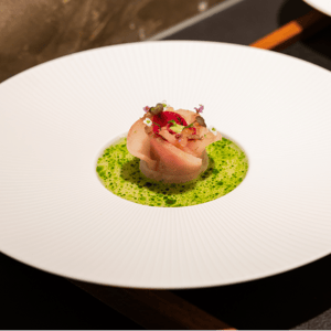 Een gastronomisch gerecht met zeevruchten, groene saus en verse garnering bij Create by Guido Braeken