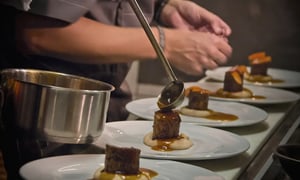 Chef plating dishes with consistent timing during fine dining service