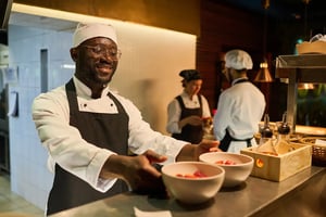 Chef serving dishes during service in a professional restaurant kitchen